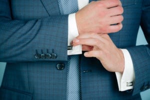 Man fixing stylish cufflinks on white shirt cuffs sleeves custom suit