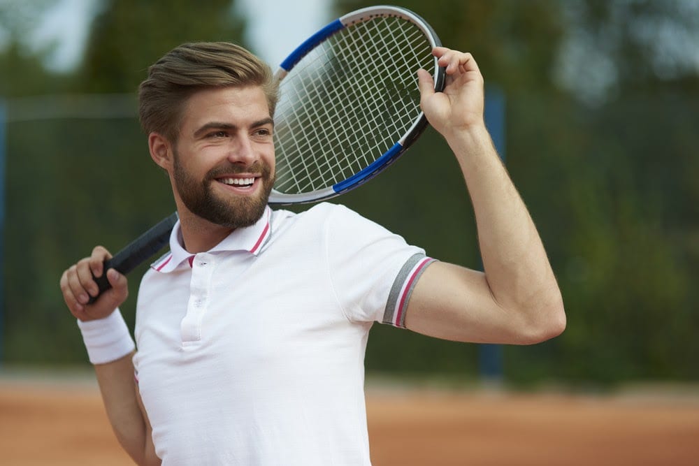 Man wearing athleisure clothing playing tennis