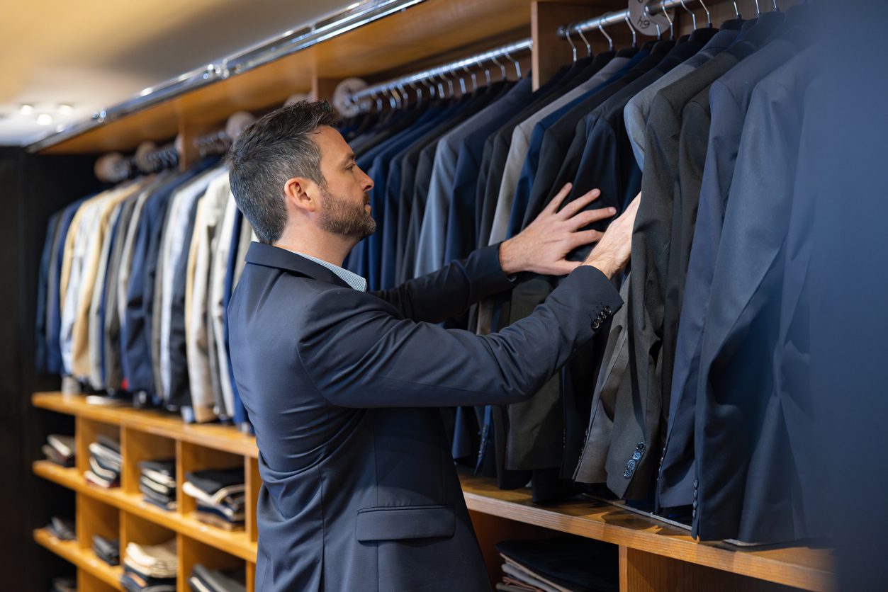 Businessman choosing a suit to suggest digitizing your closet.