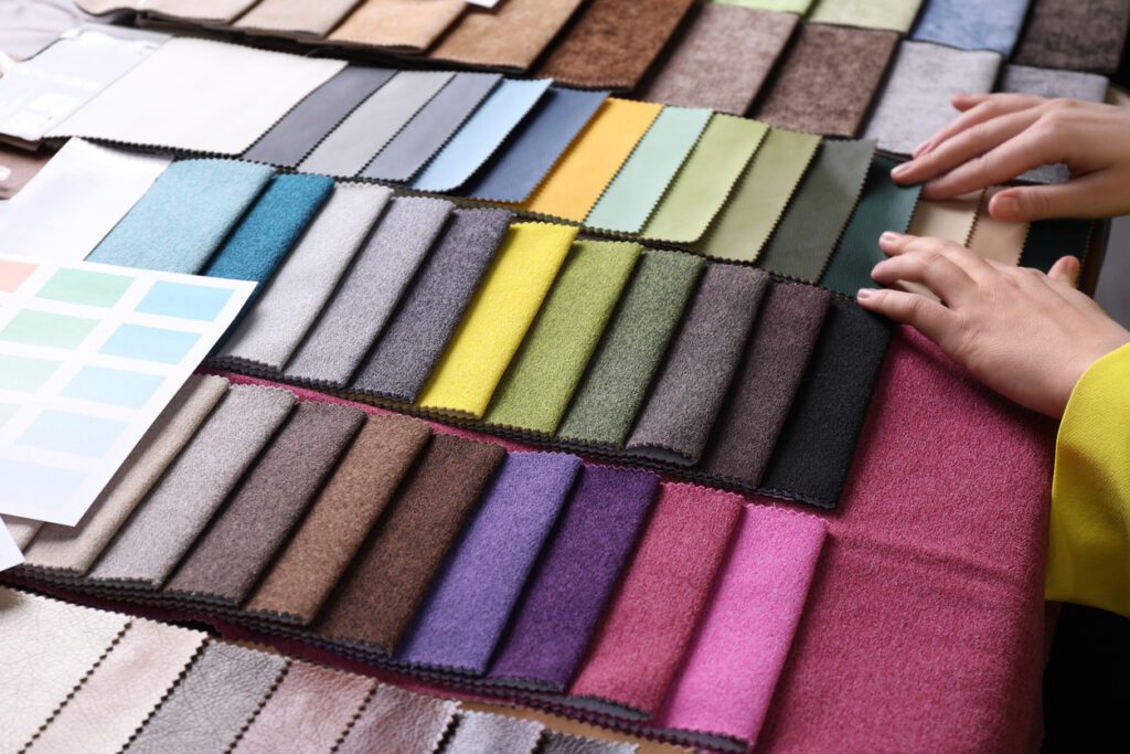 Woman choosing among colorful summer fabrics on the table.