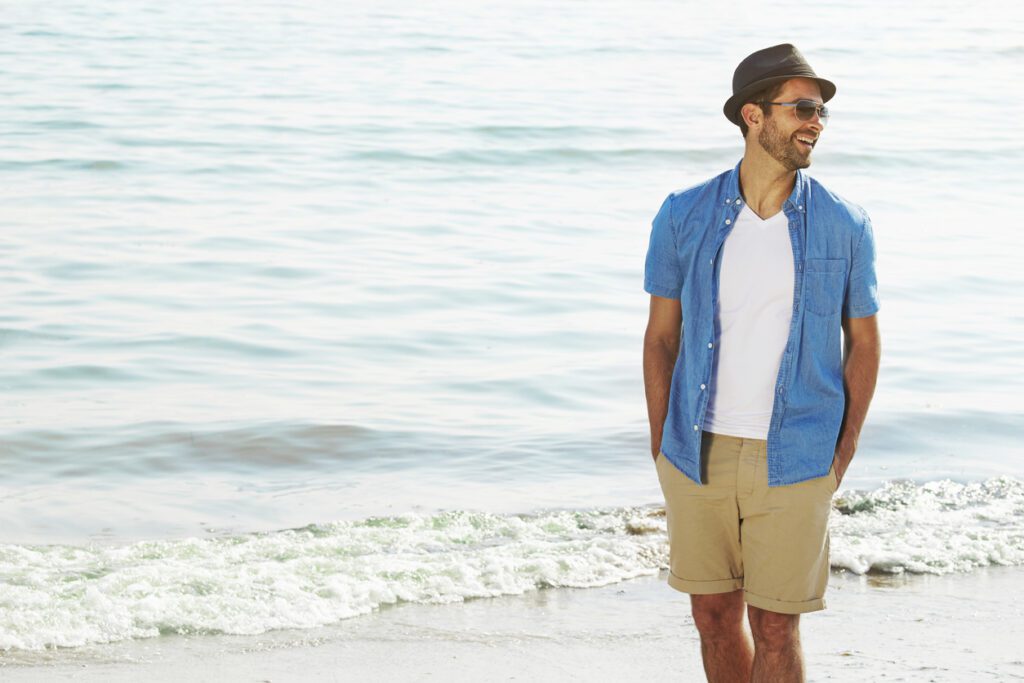 Man at the beach wearing the ideal short length and shirt.