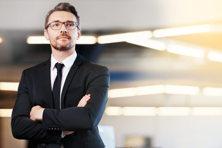 Confident businessman wearing well-fitted clothing while standing in an office.