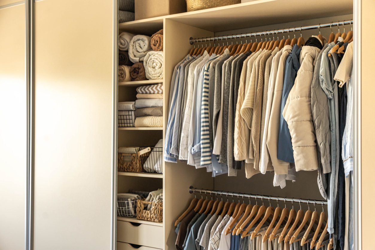 Large wardrobe closet with different clothes suggesting wardrobe organization.